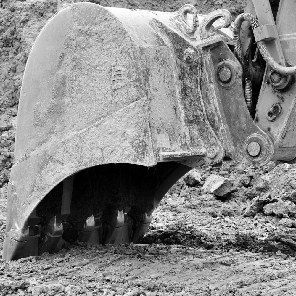 A excavator bucket digs into the ground.