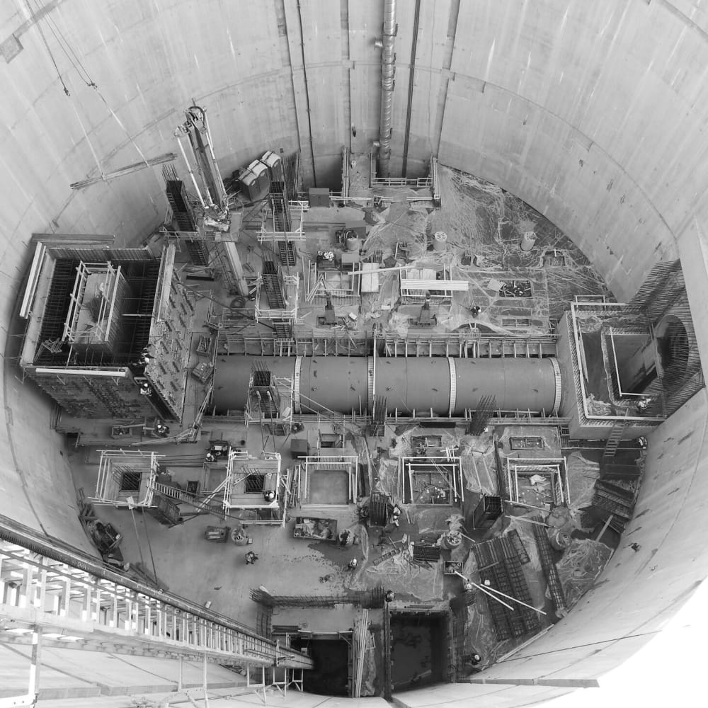 A view from above down a large underground shaft containing a pumping station.