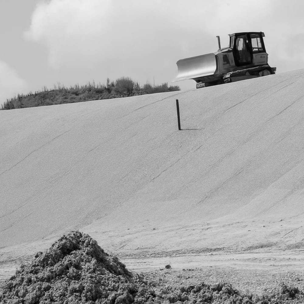 A bulldozer sits atop a hill at a remediation site.