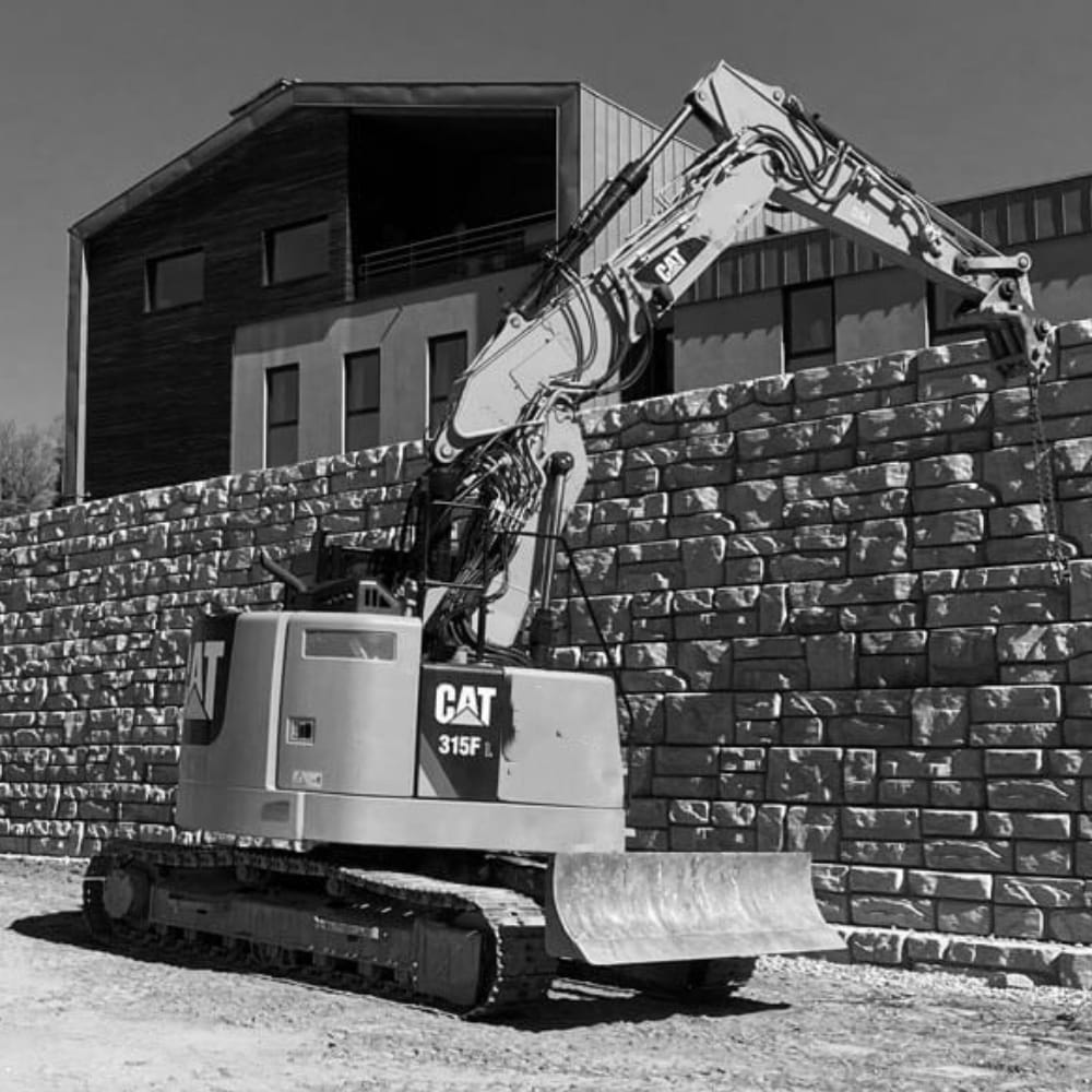 Heavy equipment works on the construction of a retaining wall.